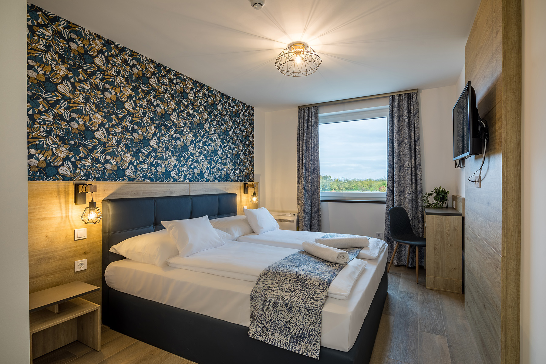 Standard hotel szoba dupla ággyal Első emeleti, dupla ágyas szobánk tökéletes egyedül utazóknak, pároknak. 180×200 cm-es ággyal, zuhanyzós fürdőszobával.