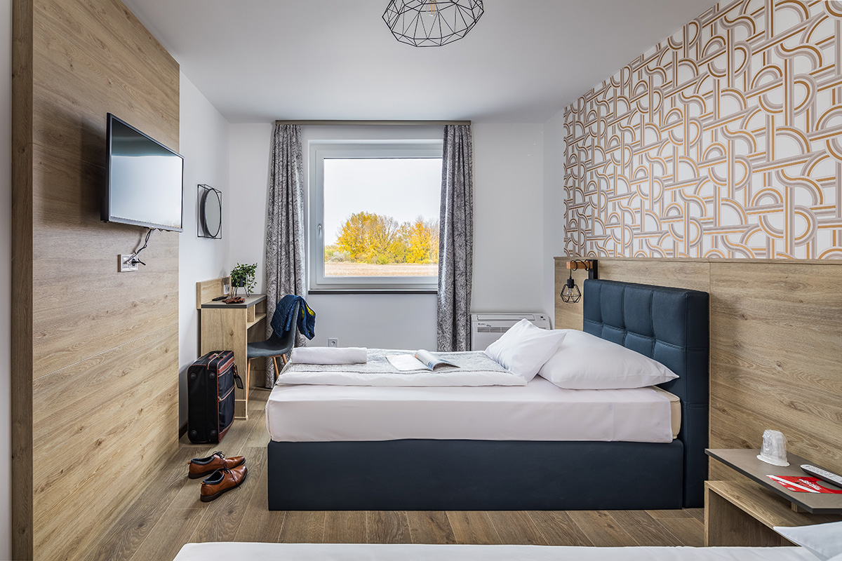 Standard hotelszoba dupla ággyal - Hegyeshalom határnál Földszinti, dupla ágyas szobánk tökéletes egyedül utazóknak, pároknak. 180×200 cm-es boxspring ágyak, zuhanyzós fürdőszoba.